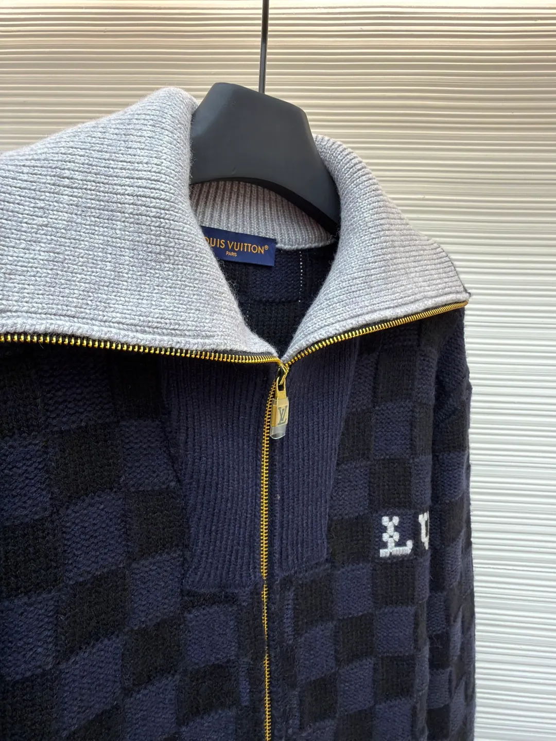 LOUIS VUITTON knitted waist contrast ribbed collar sweater ●Original version: Purchased and developed by 20433 ●Item number: 1682136-C15 ●Fabric: wool blended fabric ●Technology: knitted ●Color: black and blue ●Version: fitted version ●Weight: about 1360 grams ●Size: S-M-L-XL ●Description: This Louis Vuitton checkerboard knitted zipper jacket is made of double-ply merino wool blended yarn and is woven with a 12-needle three-dimensional knitting process on a German Stoll computerized flat knitting machine. The Damier checkerboard pattern on the body uses intarsia knitting techniques, and the layered interweaving of dark blue and black yarns creates a 3D concave and convex texture. There is no printed patchwork process, and the pattern and the body are integrated for a more textured look. The neckline is designed with contrasting ribbed lapels, and built-in spandex elastic yarn improves resilience; the metal zipper is made of gold-plated brass, and the teeth are precision polished. The zipper track and the seam of the body are sewn with overlock stitching, and the stitch length is controlled within 0.2cm. The contrasting ribbed edges on the cuffs and hem are pre-shrunk and hand-shaped and ironed, making the garment crisp and less likely to loosen after long-wearing. Every detail demonstrates the brand's strict standards of high-end knitting technology. The overall wiring is straight and delicate, the fabric is comfortable and soft, and the color is consistent without color difference. It can be matched with the same style to create a fashionable look and control various occasions. Customized accessories, complete with three standards, same style for men and women!